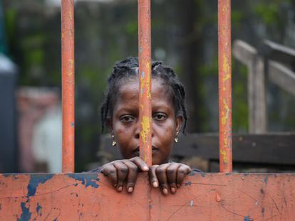 Una residente del West Point, un suburbio de Monrovia (Liberia), detr&aacute;s de una de las vallas que cierra el barrio por la cuarentena ante el &eacute;bola. 