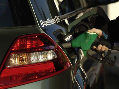 Una persona llena el depósito de su coche con bioetanol, menos contaminante que la gasolina.