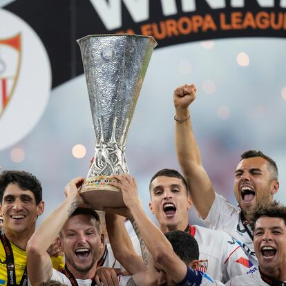 Sevilla's Ivan Rakitic holds up the winners trophy as he celebrates with teammates after winning the Europa League final soccer match against Roma at the Puskas Arena stadium in Budapest, Hungary, Thursday, June 1, 2023. Sevilla defeated Roma 4-1 in a penalty shootout after the match ended tied 1-1. (AP Photo/Darko Bandic)