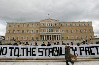 Varios activistas con una pancarta que dice "No al Pacto de Estabilidad", ante el Parlamento griego en Atenas.