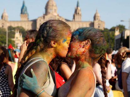 Dos jóvenes se dan un beso en la manifestación del Orgullo en Barcelona.