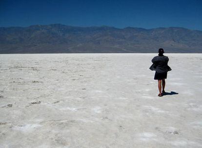 Una turista se protege del sol mientras recorre la blanca llanura de Badwater, en Death Valley (California)