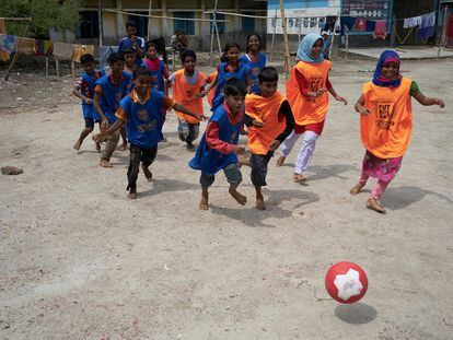 Nupur 
(al fondo, en el centro de la foto) juega 
con sus compañeros al fútbol en un campo improvisado.