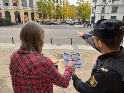 Un agente comunica con una ciudadana a través de los pictogramas que ha elaborado Arasaac para la Policía Nacional, con el objetivo de facilitar la conversación en casos de emergencia, el 16 de noviembre en Zaragoza.