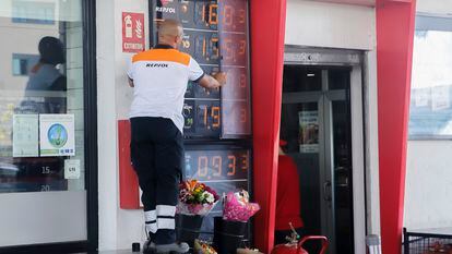Un trabajador cambia los precios de los carburantes en un panel de una gasolinera de Madrid.