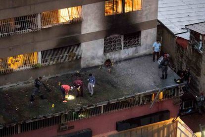 Agentes de policía recogen pruebas en un edificio cercano al suceso.