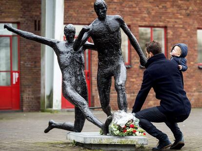 Un hombre deposita flores en la estatua de Johan Cruyff en el estadio Ol&iacute;mpico de Amsterdam donde juega el Ajax.