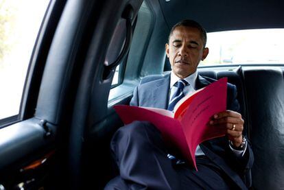 Barack Obama consulta documentos de trabajo mientras se desplaza en su coche oficial.