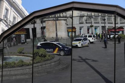 Vehículos de la Policía Nacional y Local reflejados en la pérgola de acceso a las estaciones de metro y Cercanías de la Puerta del Sol, en Madrid.