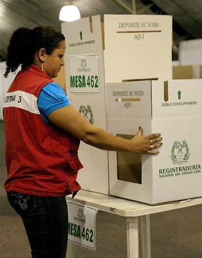 Una mujer prepara una mesa de votación en un colegio electoral en Bogotá.