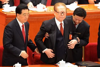 El presidente chino, Hu Jintao, ayuda al expresidente Jiang Zemin a ponerse de pie en la apertura del Congreso. Mientras Hu lució un aspecto casi juvenil a sus casi 70 años, el octogenario ex presidente subió al estrado -ocupado por los actuales 370 miembros del Comité Central y los 25 del Poliburó-, renqueante y visiblemente desmejorado.