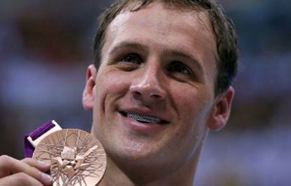 Ryan Lochte presume de medalla de bronce y de sus aparato dental con diamantes incrustados.
