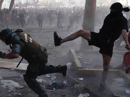 Manifestantes y carabineros se enfrentan durante la manifestación en Santiago, este martes.