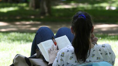 Una mujer lee en el parque del Retiro de Madrid, donde se celebra la Feria del Libro.