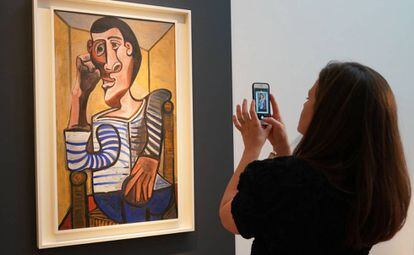Una empleada de Christie's fotografía 'El marinero', de Pablo Picasso, el pasado 3 de mayo en la casa de subastas, en Nueva York.