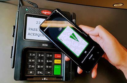 Una persona paga con la tarjeta de El Corte Ingl&eacute;s desde el m&oacute;vil a trav&eacute;s de la plataforma Samsung Pay.
