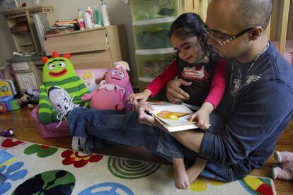 Christopher Astacio lee con su hija, Cristina de dos años, diagnosticada de autismo.