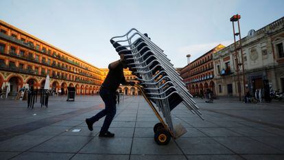 Un trabajador recoge la terraza de su bar en Córdoba el pasado 20 de julio.