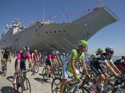 Los corredores pedalean junto al portaaviones Juan Carlos I.