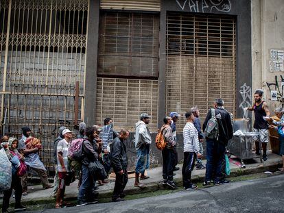 Personas sin techo hacen cola para recibir un plato de comida en una calle de São Paulo (Brasil), el 21 de octubre de 2022.