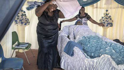 Mujeres flanquean a la difunta durante el sepelio.