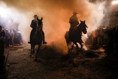 Los jinetes y sus caballos han pasado junto a las hogueras hasta que sus llamas han quedado casi extinguidas.
