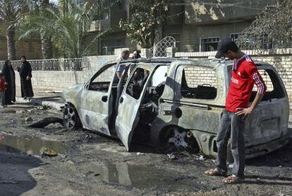 Un hombre contempla un automóvil calcinado por un ataque perpetrado en el barrio de Al Karrada, en Bagdad.