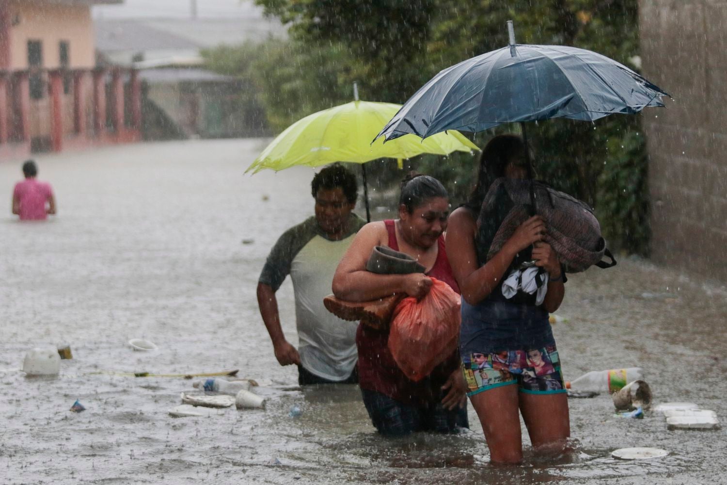 Eta se debilitó de un huracán de categoría 4 a una tormenta tropical,
residentes caminan a través de una carretera inundada con algunas pertenencias, en Progreso Yoro, Honduras.