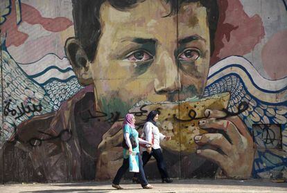 Dos mujeres egipcias caminan delante de un mural de la Revoluci&oacute;n Egipcia, que reclamaba justicia social. 