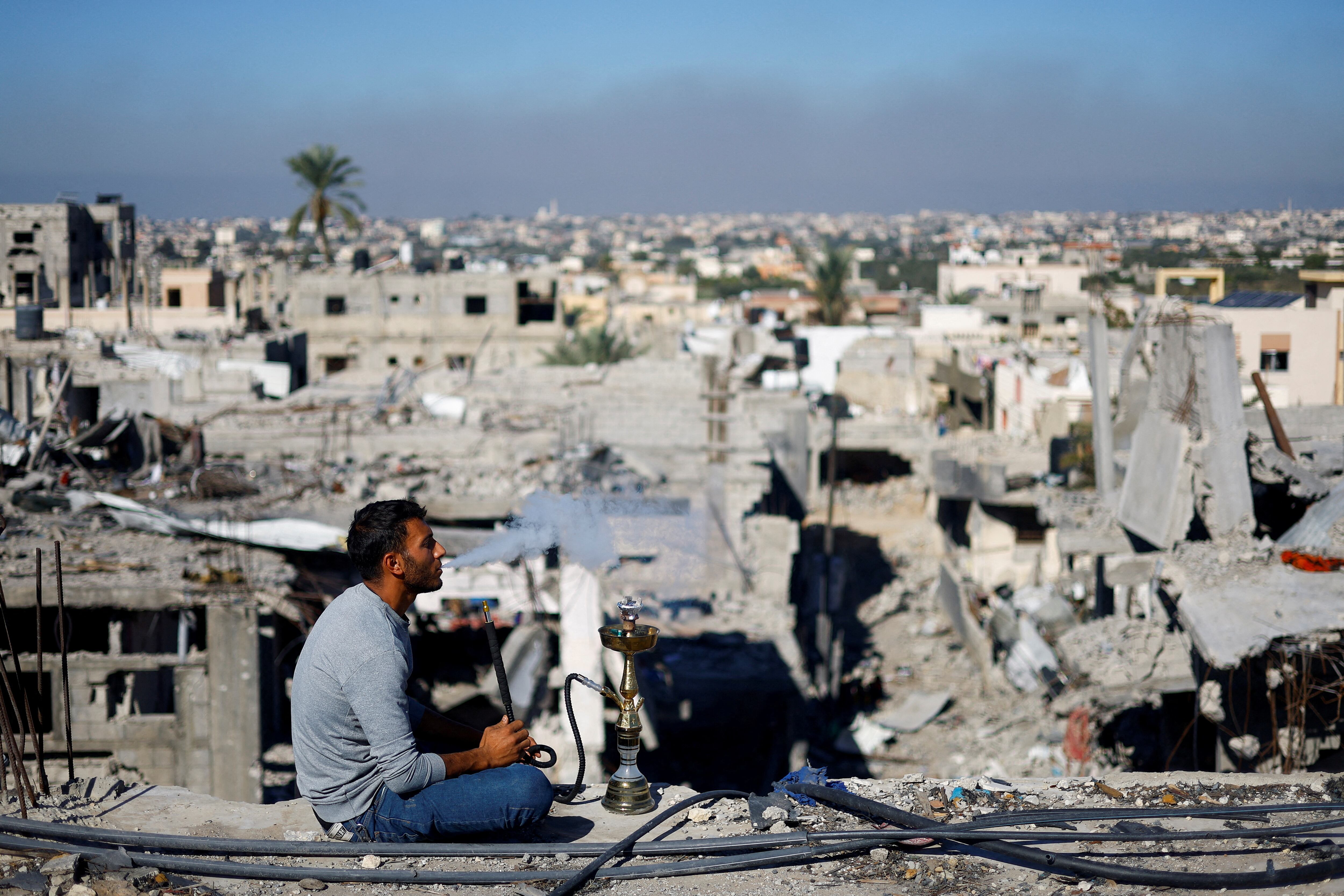 Un hombre palestino fuma entre las ruinas del campo de refugiados de Jan Yunis, en el sur de la franja de Gaza.