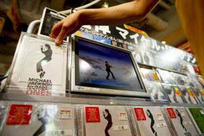 Un empleado de una tienda de música coloca CDs y DVDs de la estrella del pop Michael Jackson, en Tokio (Japón). EFE/Archivo