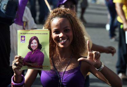 Una mujer muestra un cartel electoral de Margarita Cedeño, actual primera dama y candidata a vicepresidenta.