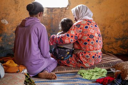 Sanaa, que fue violada desde los 11 años (izquierda), junto a su hijo, de un año, en brazos de su abuela, Jaiat, en su casa de Tiflet (Marruecos).