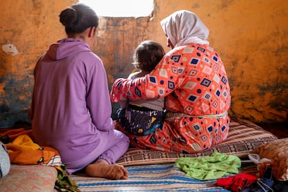 Sanaa, que fue violada desde los 11 años (izquierda), junto a su hijo, de un año, en brazos de su abuela, Jaiat, en su casa de Tiflet (Marruecos).