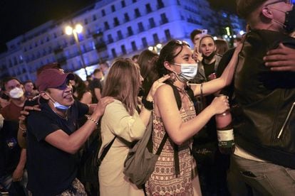 Cientos de personas celebran en la Puerta del Sol de Madrid el fin del estado de alarma. La primera madrugada sin estado de alarma se ha vivido en muchas partes de España como una gran fiesta, una Nochevieja adelantada a mayo con botellones en las principales plazas, en muchos casos a voz en grito y sin medidas de seguridad.