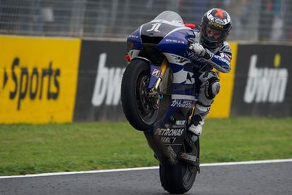 Lorenzo celebra su victoria levantando la parte delantera de su moto.