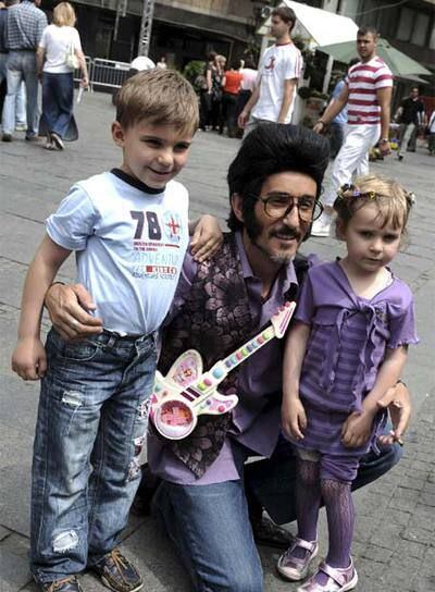 Chikilicuatre posa con dos niños en una calle de Belgrado.