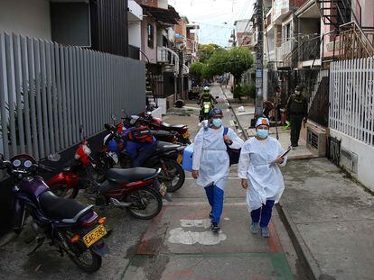 Dos trabajadores de la salud caminan con la vacuna del laboratorio chino Sinovac, en un barrio de Cali, Colombia, el 18 de marzo pasado.