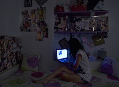 Una adolescente <i>chatea</i> de madrugada a través
 del portátil instalado en su dormitorio.
 La policía recomienda a los padres que cuiden
de que el ordenador esté en una habitación común.