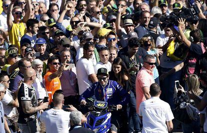 El piloto italiano de Yamaha Valentino Rossi, intenta abrirse paso ante miles de aficionados en el paddock del circuito Ricardo Tormo de Cheste ,Valencia, donde mañana se celebra la última prueba del mundial de motociclismo.