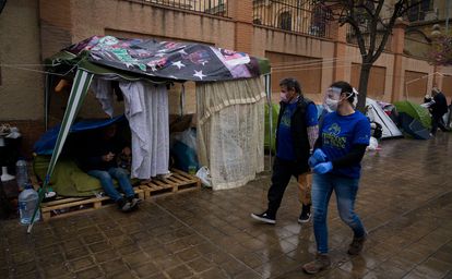 Varios voluntarios reparten comida a personas sin hogar, el pasado jueves en Valencia.