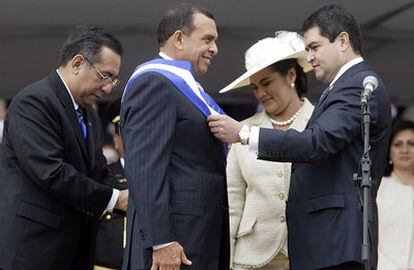 El presidente electo de Honduras, Porfirio Lobo (Izq.), recibe la banda presidencial del jefe del Congreso