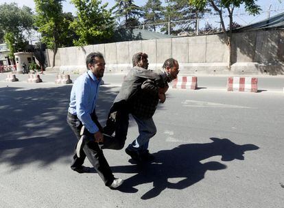Dos hombres afganos cargan con un herido.