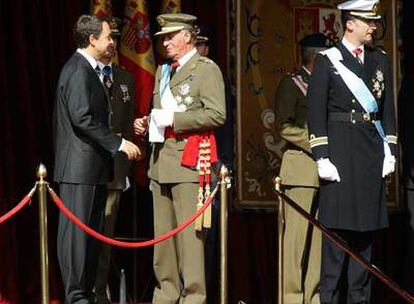 José Luis Rodríguez Zapatero charla con el Rey, en presencia del Príncipe de Asturias, en la tribuna del desfile de la Fiesta Nacional de 2004.