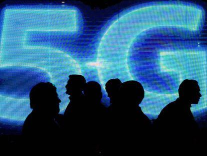 P&uacute;blico del Mobile World Congress de Barcelona ante un luminoso que hace referencia a la tecnolog&iacute;a 5G.