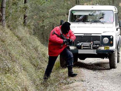 Un <i>ertzaina</i> armado peina la zona donde fue hallado el zulo de ETA.