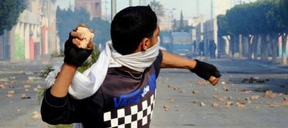 Un joven tunecino lanza una piedra contra la policía en la ciudad de Regueb.