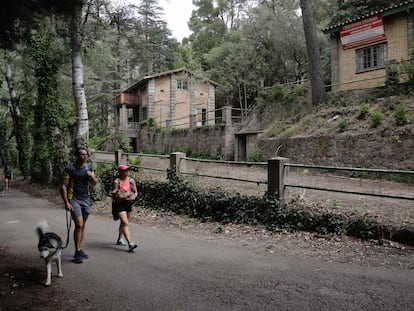 Dos personas pasean con un perro junto al antiguo poblado de Camarasa