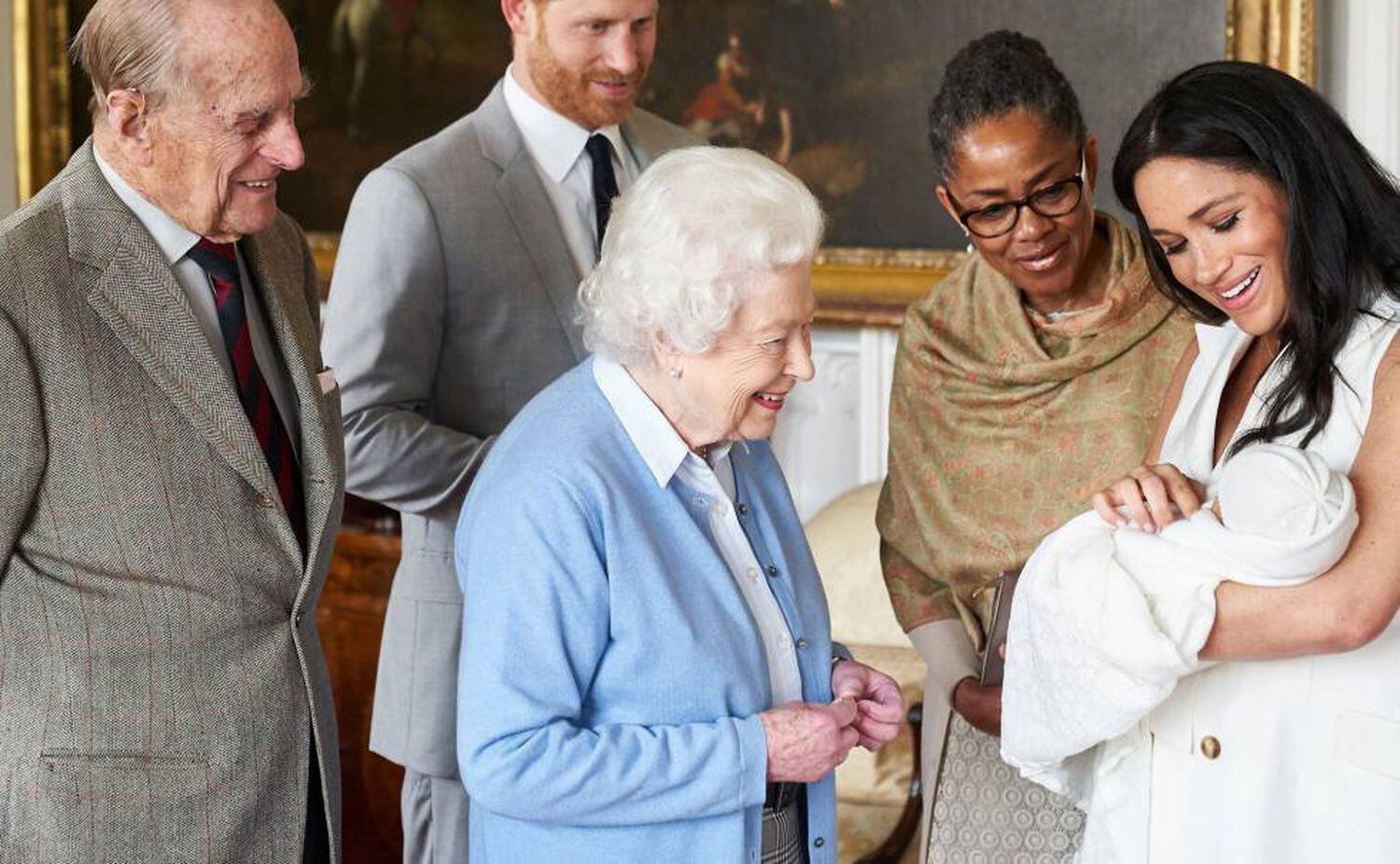 El príncipe Enrique de Inglaterra (segundo por la izquierda) y la duquesa de Sussex, Meghan Markle (a la derecha), presentan a su hijo recién nacido, Archie Harrison Mountbatten-Windsor, a la reina Isabel II de Inglaterra (centro) y a su esposo Felipe, duque de Edimburgo, en el castillo de Windsor (Reino Unido), junto a la madre de la duquesa de Sussex, Doria Ragland, el 8 de mayo de 2019.