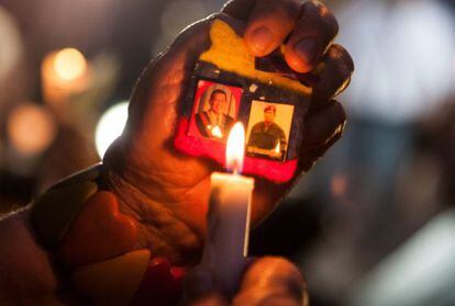 Una persona sostiene dos fotografías del Presidente de Venezuela Hugo Chávez durante un ritual indígena por su salud
